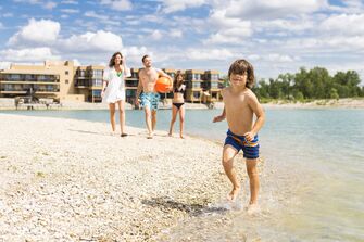 Familie spielt auf der Summer Island der St. Martins Therme und Lodge mit einem Ball
