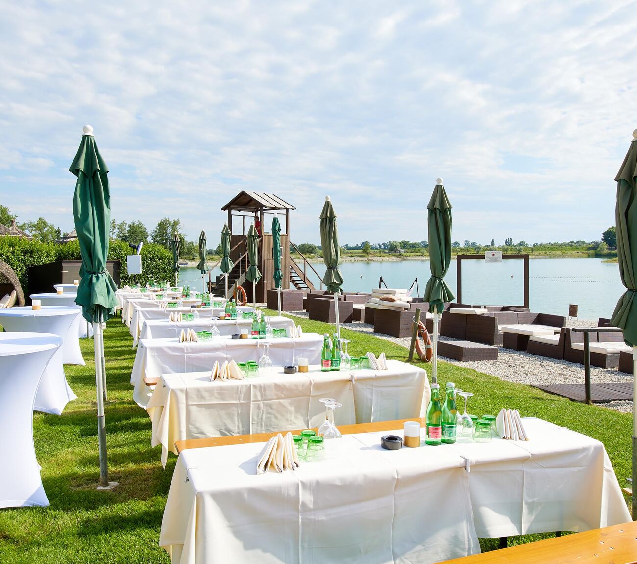 Aufgereihte gedeckte Tische, geschlossenen grünen Sonnenschirmen und Lounge-Bereichen auf Summer Island.