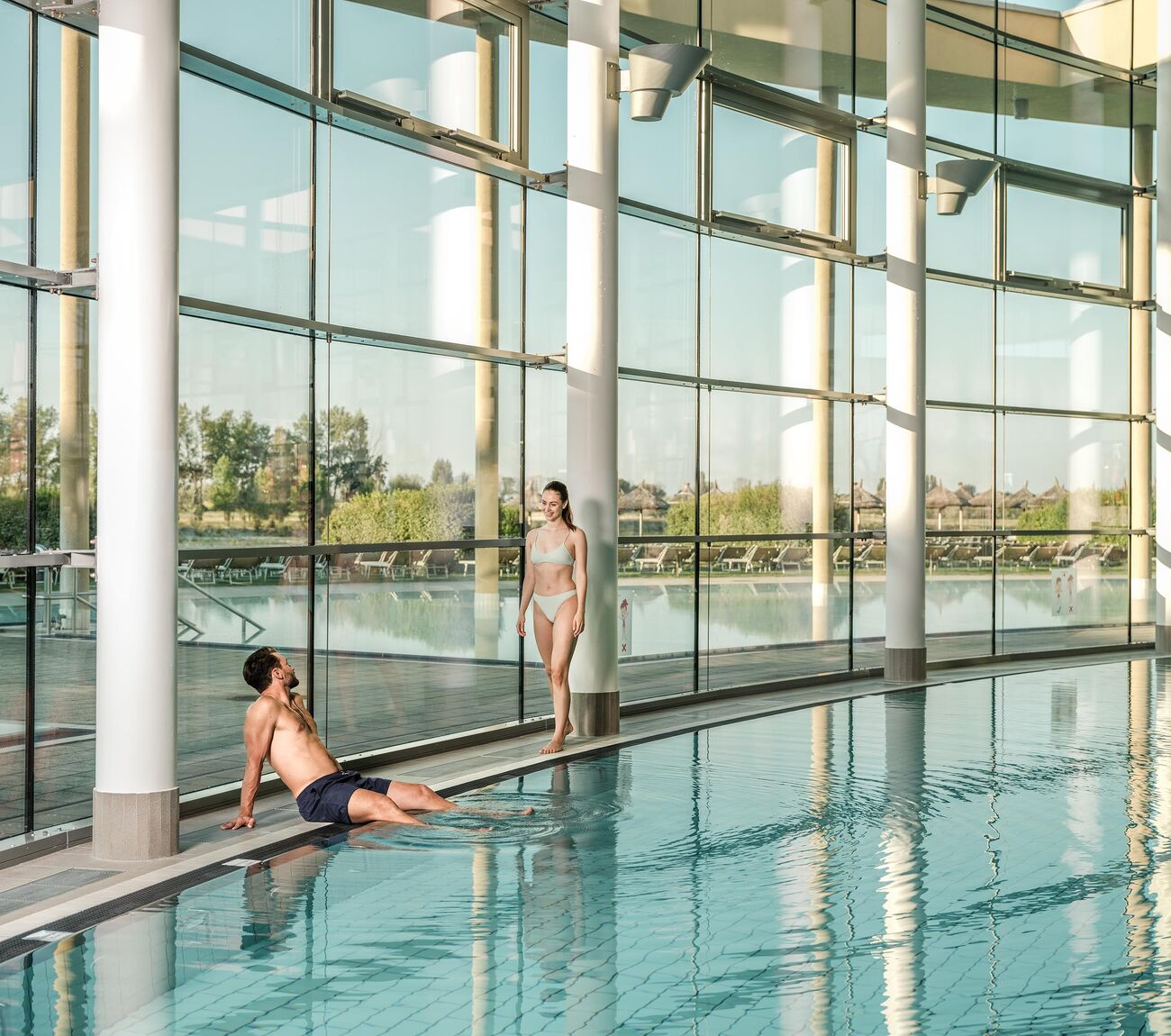 Pärchen sitzt am Beckenrand des Innenbeckens der St. Martins Therme