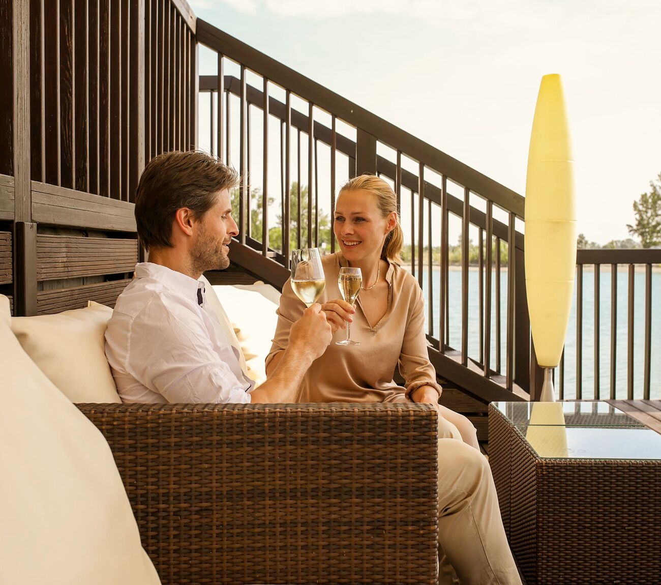 Pärchen stößt mit einem Sekt auf der Terrasse der Hemingway's Lunge der St. Martins Lodge an