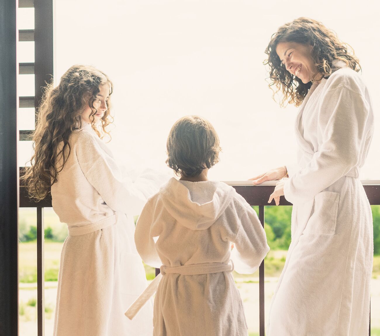 Familie steht am Balkon der Entdecker Junior Suite mit Seeblick der St. Martins Lodge